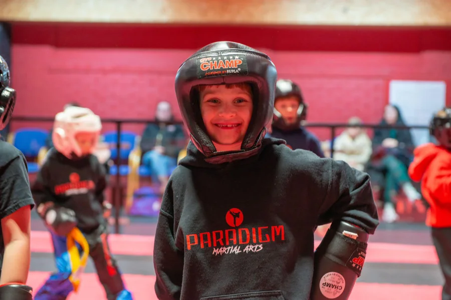 A Paradigm junior in headgear and a club hoodie between drills